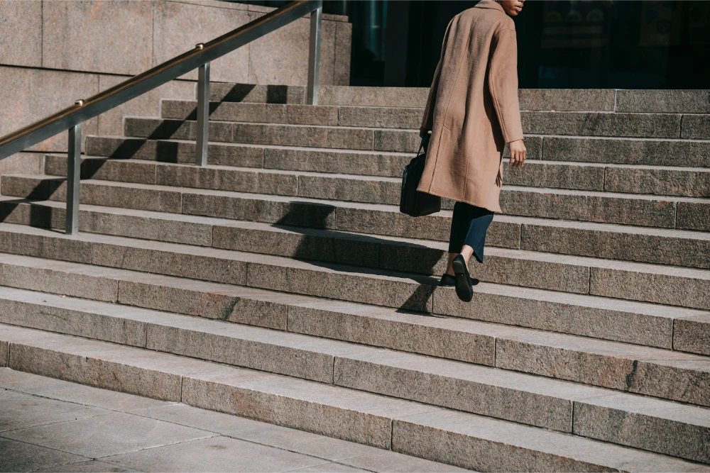 Person descending outdoor stone stairs, illustrating stairway accident risks and legal representation.