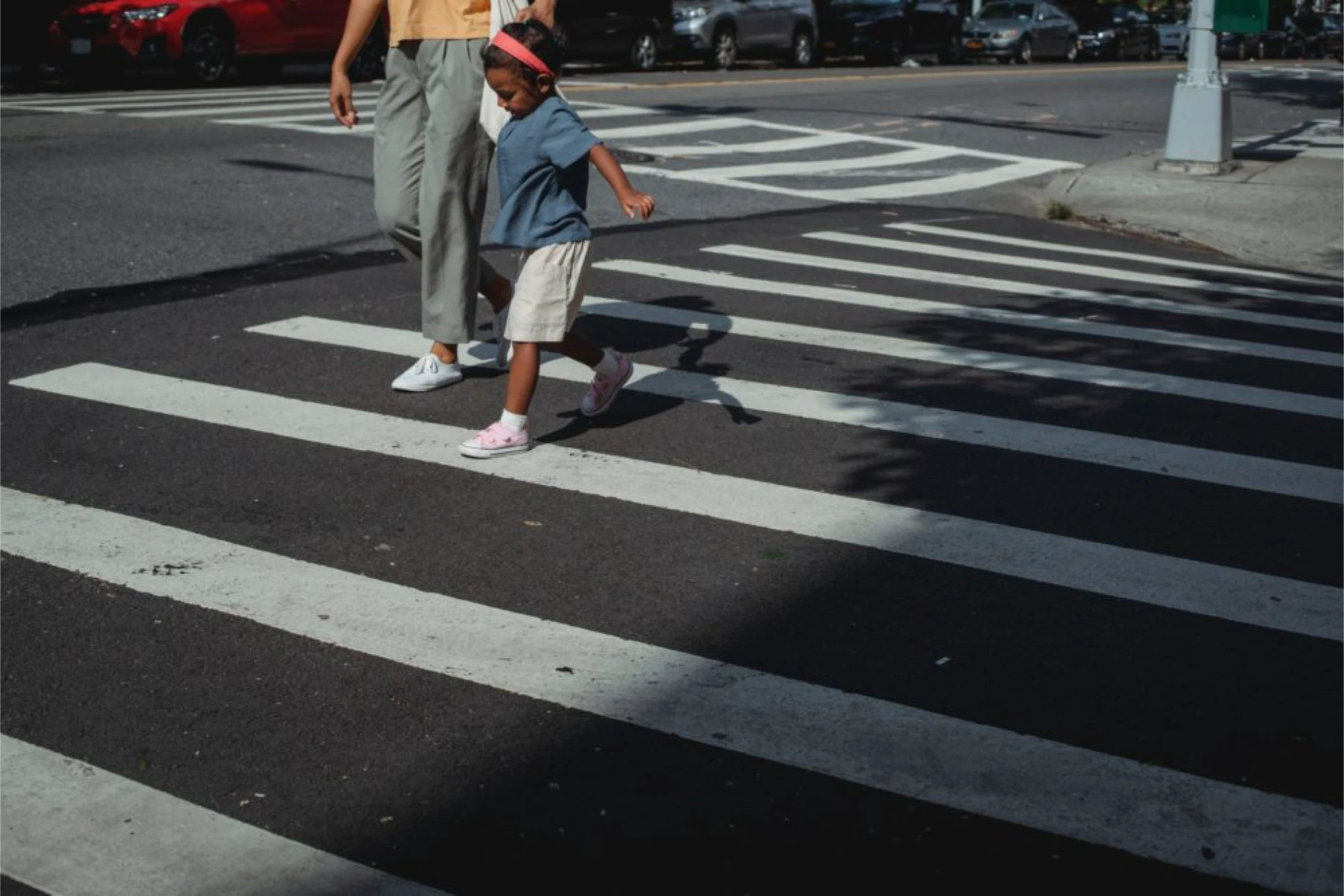 Pedestrian crossing crosswalk with child and adult illustrating pedestrian accident risks in Tampa.