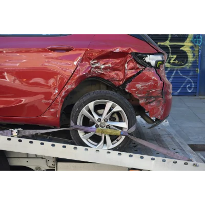 Damaged red car on a tow truck illustrating vehicle accident legal representation.