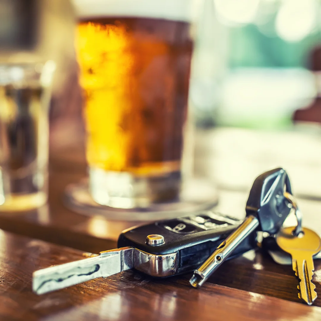 Glass of beer and car keys illustrating dangers of drunk driving accidents.