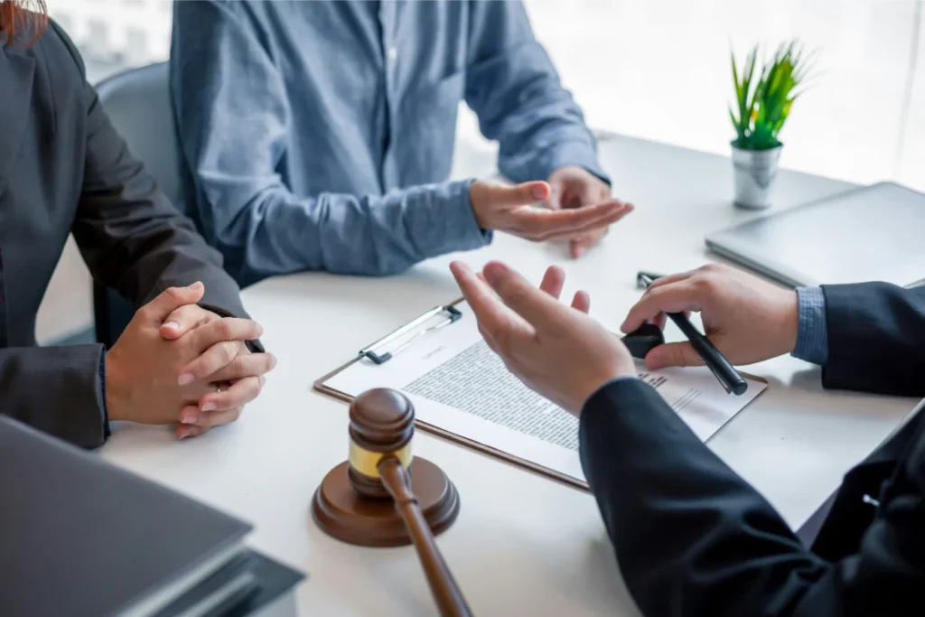 Legal consultation with attorneys discussing class action lawsuit details and gavel.