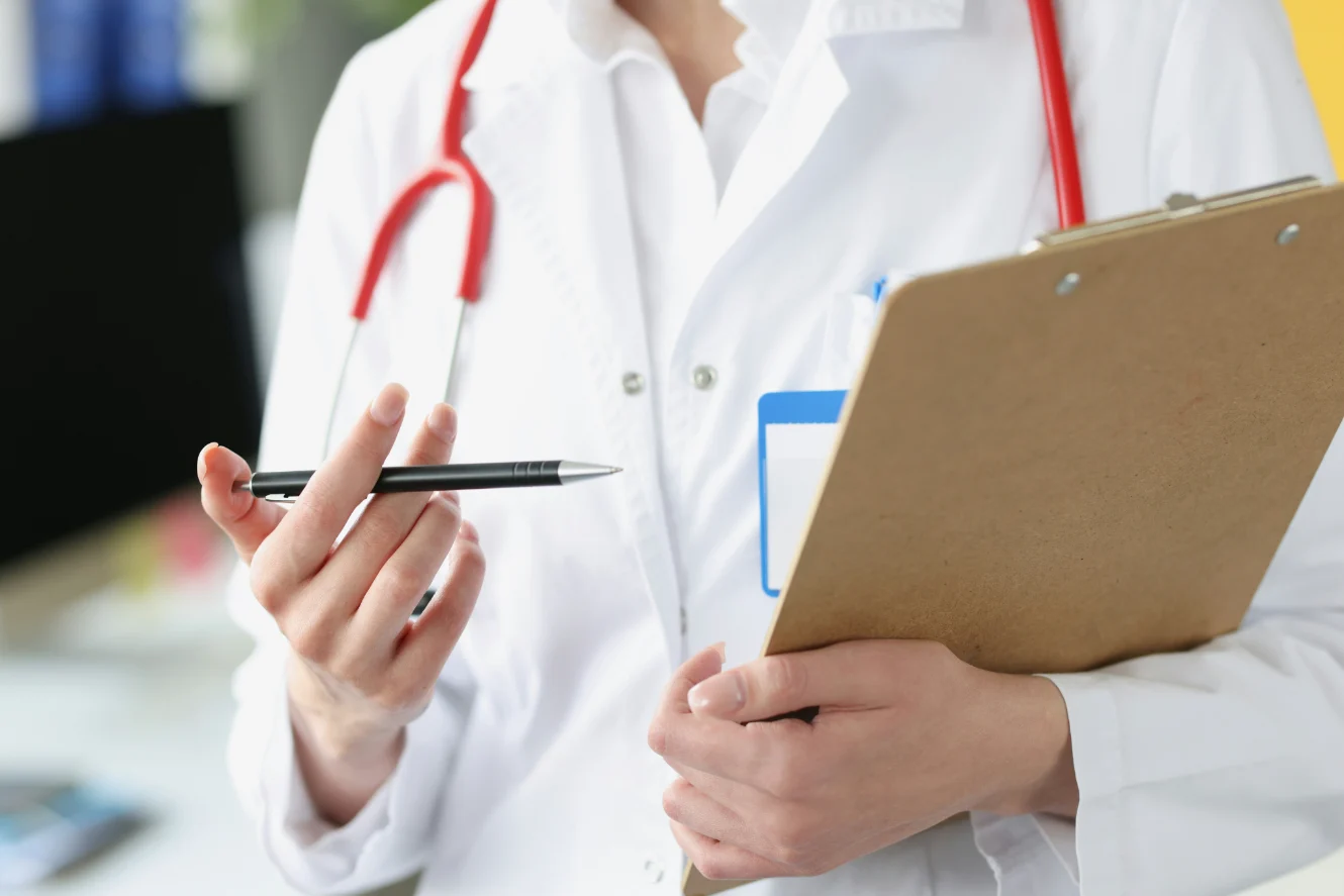 Doctor with stethoscope and clipboard, examining medical records and patient care.